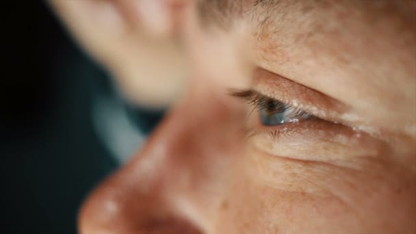 Крупним планом дорослий чоловік з блакитними очима читає і потирає очі — стокове відео