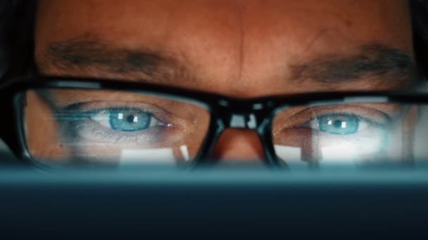 Zamknij człowieka z niebieskimi oczami, programowanie komputera i zdejmując okulary pocierać jego oczy — Wideo stockowe
