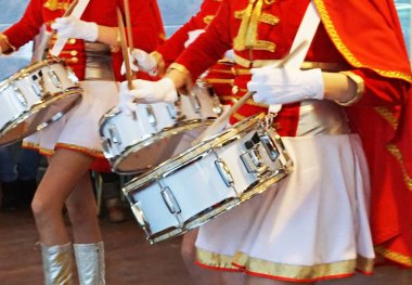 Kızım, kırmızı süvari kostümlü davulcular.