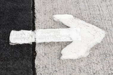 Sürücülerin trafik akışının yönünü gösteren beyaz bir okun görüntüsü.