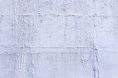 Kaba dokulu bir yüzeyi ahşap kaplamalarla betimleyen bir beton duvar parçası.                               