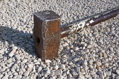 Moloz üzerinde büyük demir bir çekicin fotoğrafı.                                