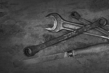 Eski ahşap masadaki eski model paslı araçları kapat: boru anahtarı ve diğer