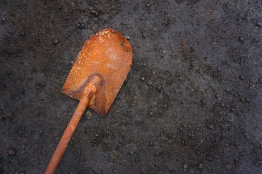 Karanlık zeminde eski paslı bir kürek.                                