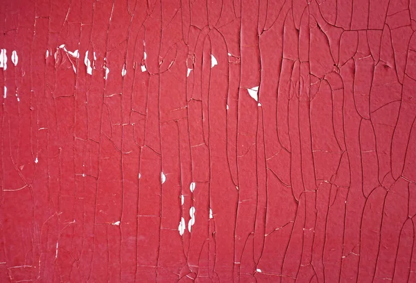 Cracked red paint texture. Close-up of old painted red wall. Abstract grunge background. Vintage scratched surface.