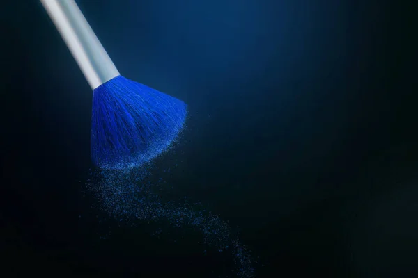 One Makeup Brush on a black background