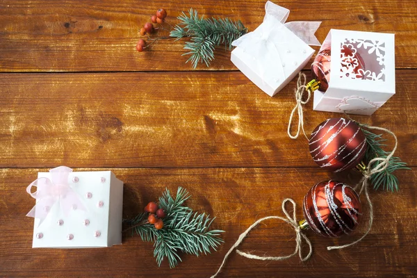 Hediye kutusu ile Noel kompozisyon ve ahşap masa ışık, kırmızı topları.