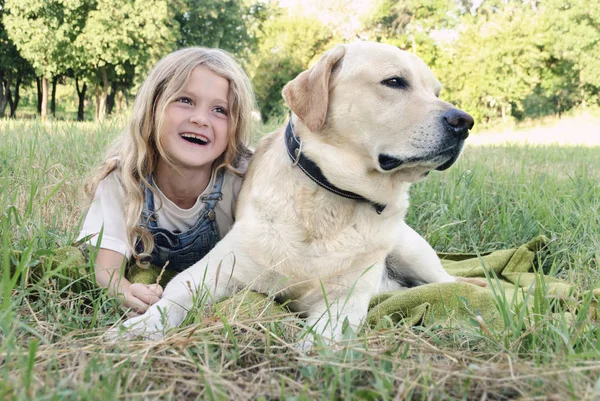 Schöne Mädchen und ein Labrador in einem Sommerpark — Stockfoto