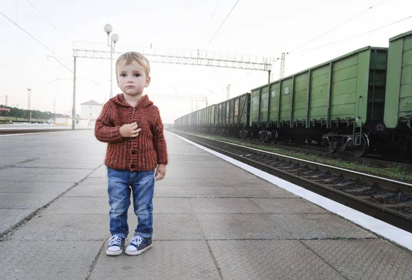 The little boy is standing at the railway station — Stock Photo, Image