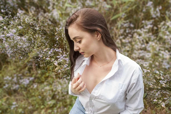 Bella ragazza triste in camicetta bianca pensiero, contro parco estivo . — Foto Stock