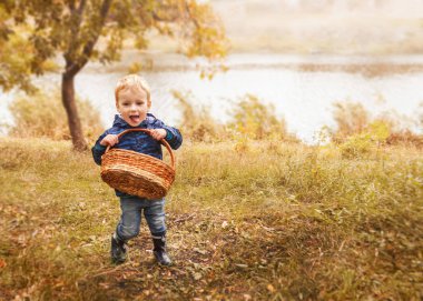 Sepet sonbahar orman içinde olan küçük çocuk