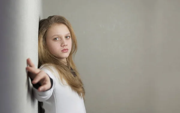 Portrait of sad blond teen girl standing near wall — Stock Photo, Image