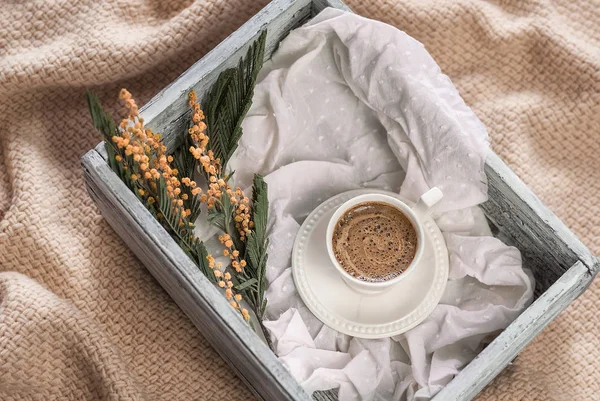 Una taza de café y una caja de madera sobre un tejido a cuadros —  Fotos de Stock