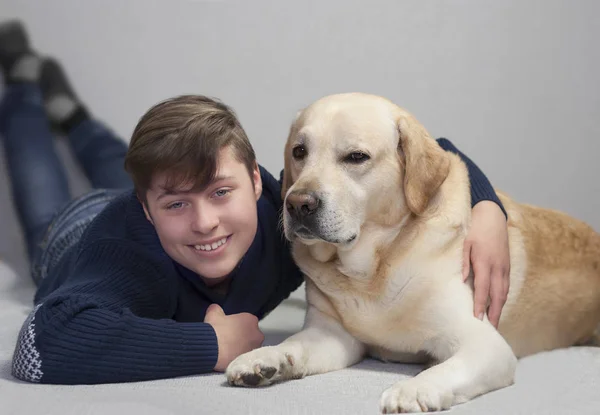 Adolescente menino e labrador amarelo — Fotografia de Stock