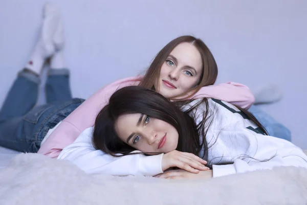 Retrato de dos hermanas tiradas en el suelo sonriendo . — Foto de Stock