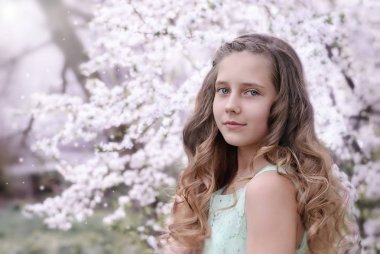 bir çiçekli ağaç arka plan üzerinde güzel küçük kız