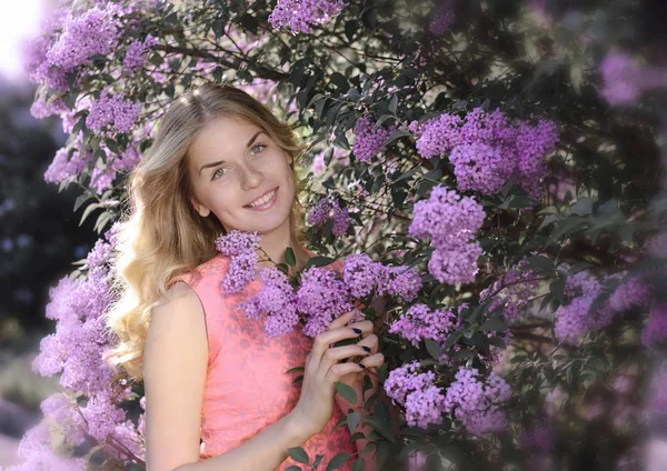 Ung vacker kvinna nära den blommande busken — Stockfoto