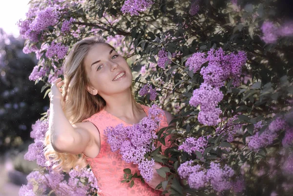 Giovane bella donna vicino all'arbusto fiorito — Foto Stock