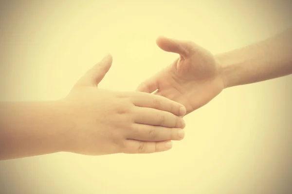 Pacto entre um jovem e um adulto com um aperto de mão — Fotografia de Stock