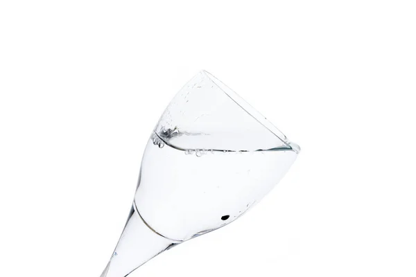 Ein Wasserglas auf weißem Hintergrund, isoliert im Gegenlicht — Stockfoto