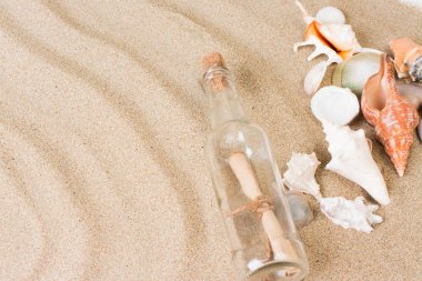 Mesaj şişe sahilde. Sıcak kum ile yaz arka plan