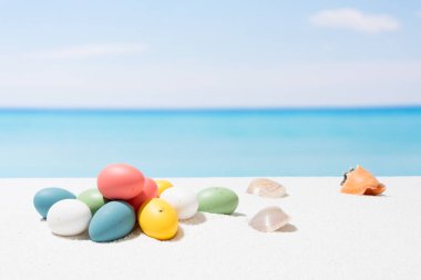 Tropikal plaj arka plan üstünde Paskalya yortusu. Yumurta beyaz kum üzerinde. VAC