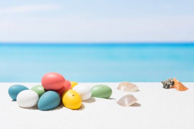 Tropikal plaj arka plan üstünde Paskalya yortusu. Yumurta beyaz kum üzerinde. VAC