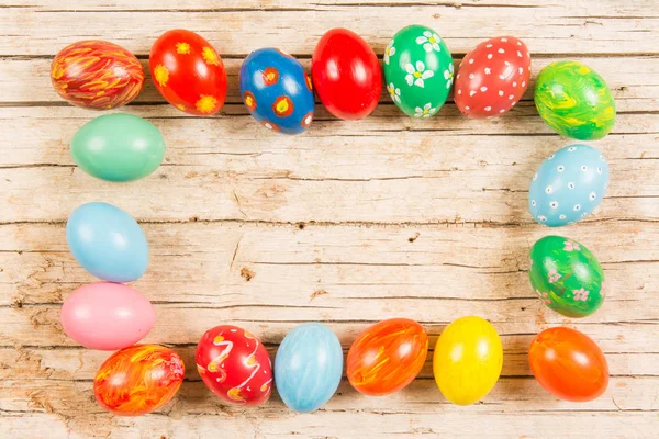 Fond de Pâques avec des œufs colorés faits main sur une table en bois. Fr — Photo