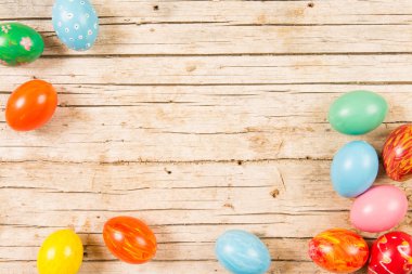 Paskalya arkaplanı, ahşap masada el yapımı yumurtalar. Öne