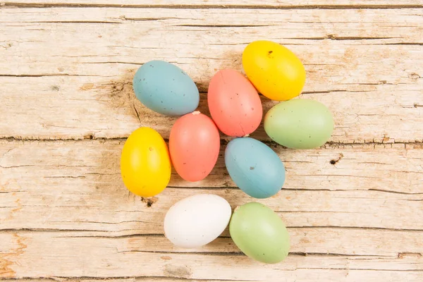 Fond de Pâques avec des œufs colorés faits à la main sur une table en bois. — Photo