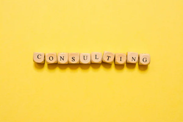 Das Wort Consulting Text Mit Würfeln Auf Gelbem Hintergrund — Stockfoto