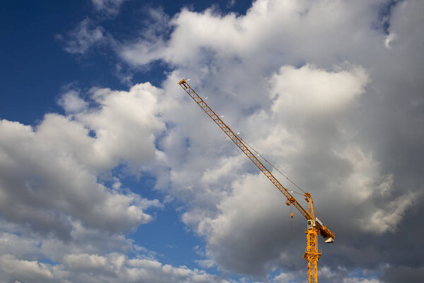 Heavy construction crane with blue cloudy sky