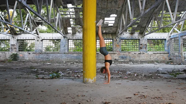 Fitness girl training hard in abandoned ruined factory building