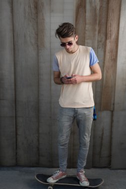 Genç kaykaycı çocuk Smartphone kullanarak 