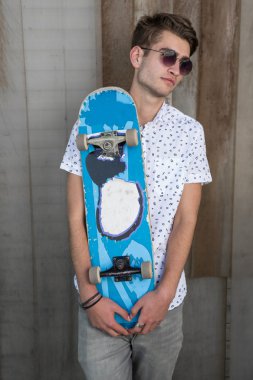 Kaykay ile beyazlı genç adam