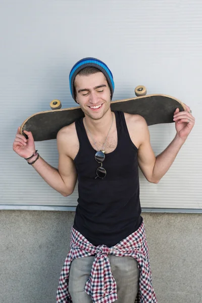 Glimlachende man met skateboard — Stockfoto