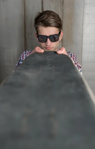 Giovane uomo in possesso di skateboard — Foto Stock