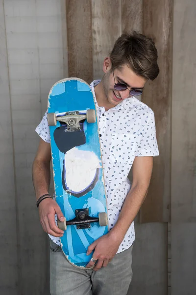 Νεαρός άνδρας σε λευκό με skateboard — Φωτογραφία Αρχείου