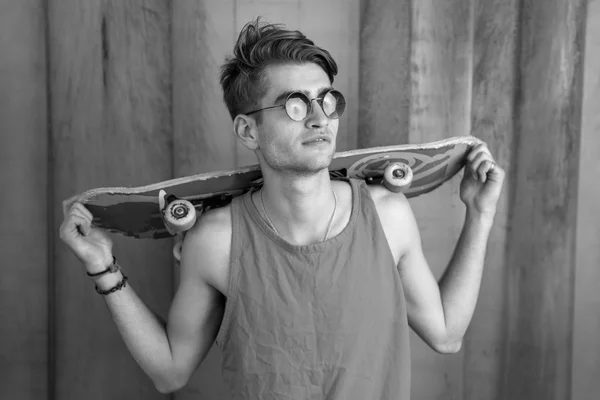 Jeune homme de la mode avec un skateboard — Photo
