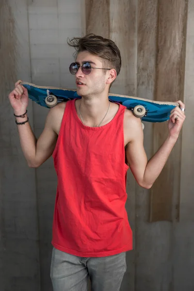 Jonge mode kerel met een skateboard — Stockfoto