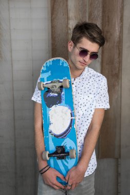 Kaykay ile beyazlı genç adam