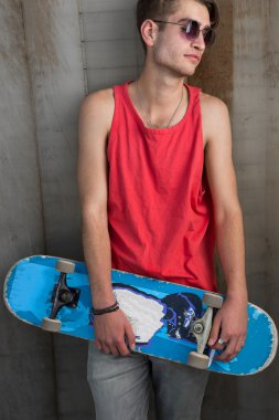 Kırmızı mavi kaykay üzerinde şehir sokak ile genç adam