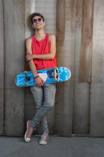 Man in het rood met blauwe skateboard — Stockfoto