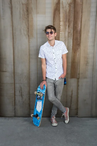 Giovane ragazzo di moda con uno skateboard — Foto Stock