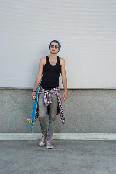 Man with skateboard on city street — Stockfoto