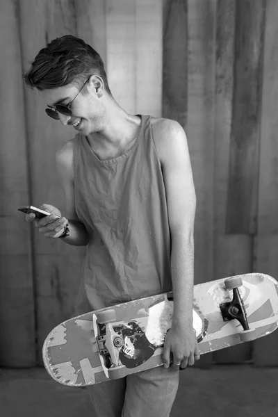 Ragazzo skater adolescente utilizzando smartphone — Foto Stock