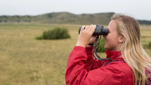 Woman with binoculars hiking in mountains — Stock Photo, Image