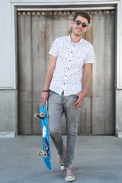 Jovem moda cara com um skate — Fotografia de Stock