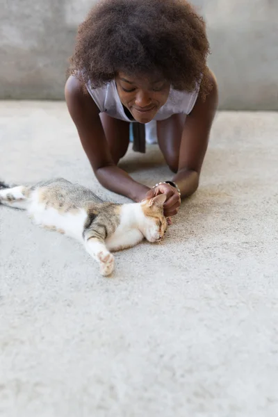 afro woman with cat on terrace