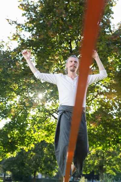 Hombre practicando la línea floja en el parque —  Fotos de Stock